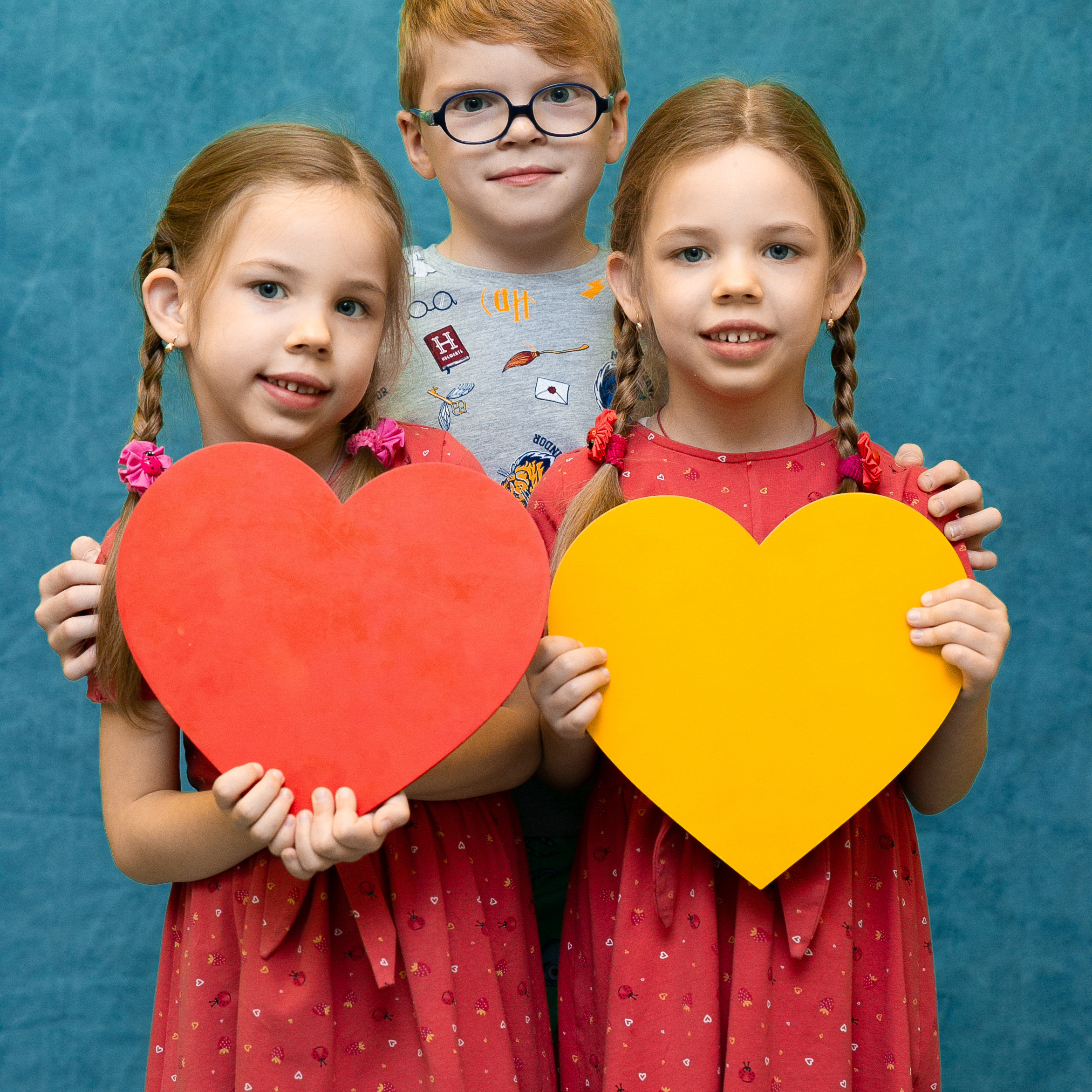 Школьники в ярких шарфах в зимнем лесу.