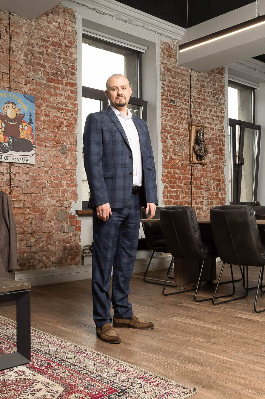 Мужчина стоит на деревянном полу для фотосессии в его офисе