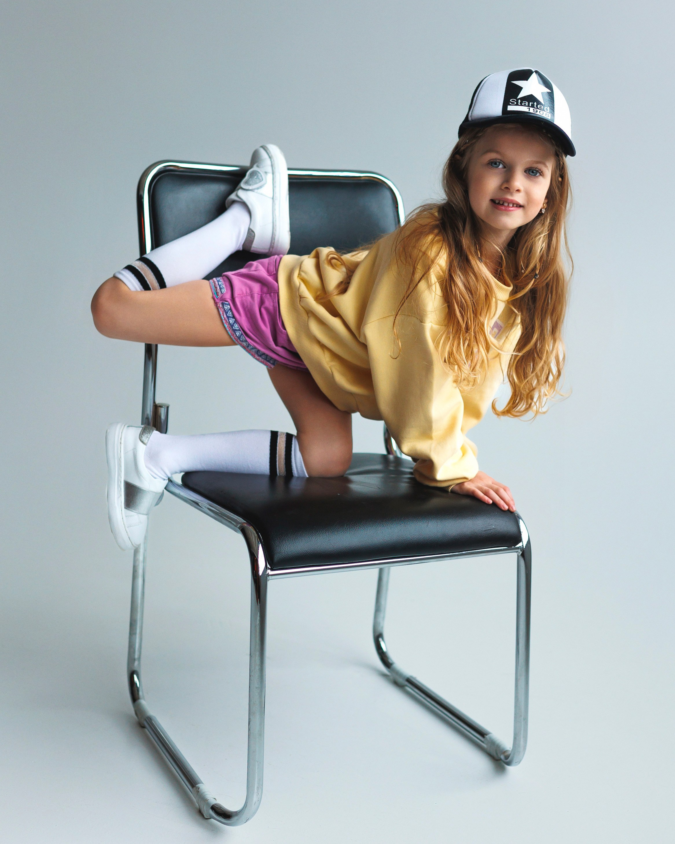 Детская фотосессия девочки 5-7 лет в студии — динамичный портрет на черном стуле, детский фотограф Минск