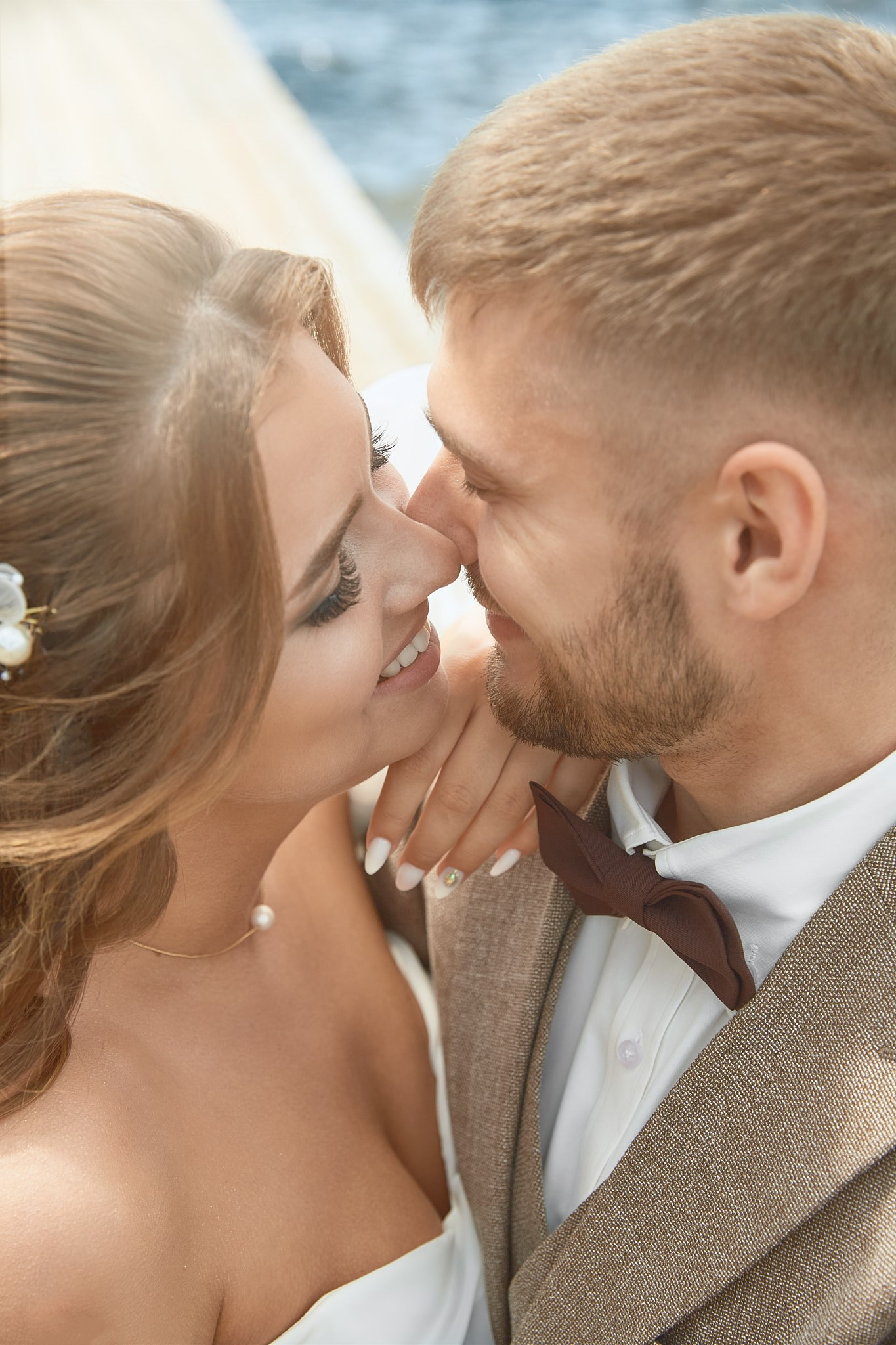 Свадебная пара: жених в бежевом костюме и коричневой бабочке, невеста в элегантном белом платье с жемчужным ожерельем | свадебный фотограф Екатеринбург