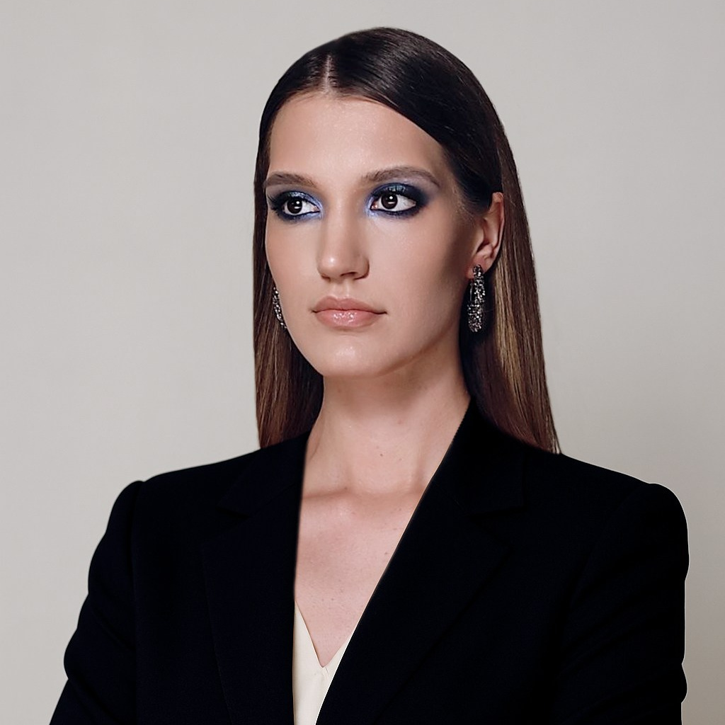 Портрет девушки в чёрном пиджаке на светлом фоне. Уверенность и профессионализм в выборе фотографа.