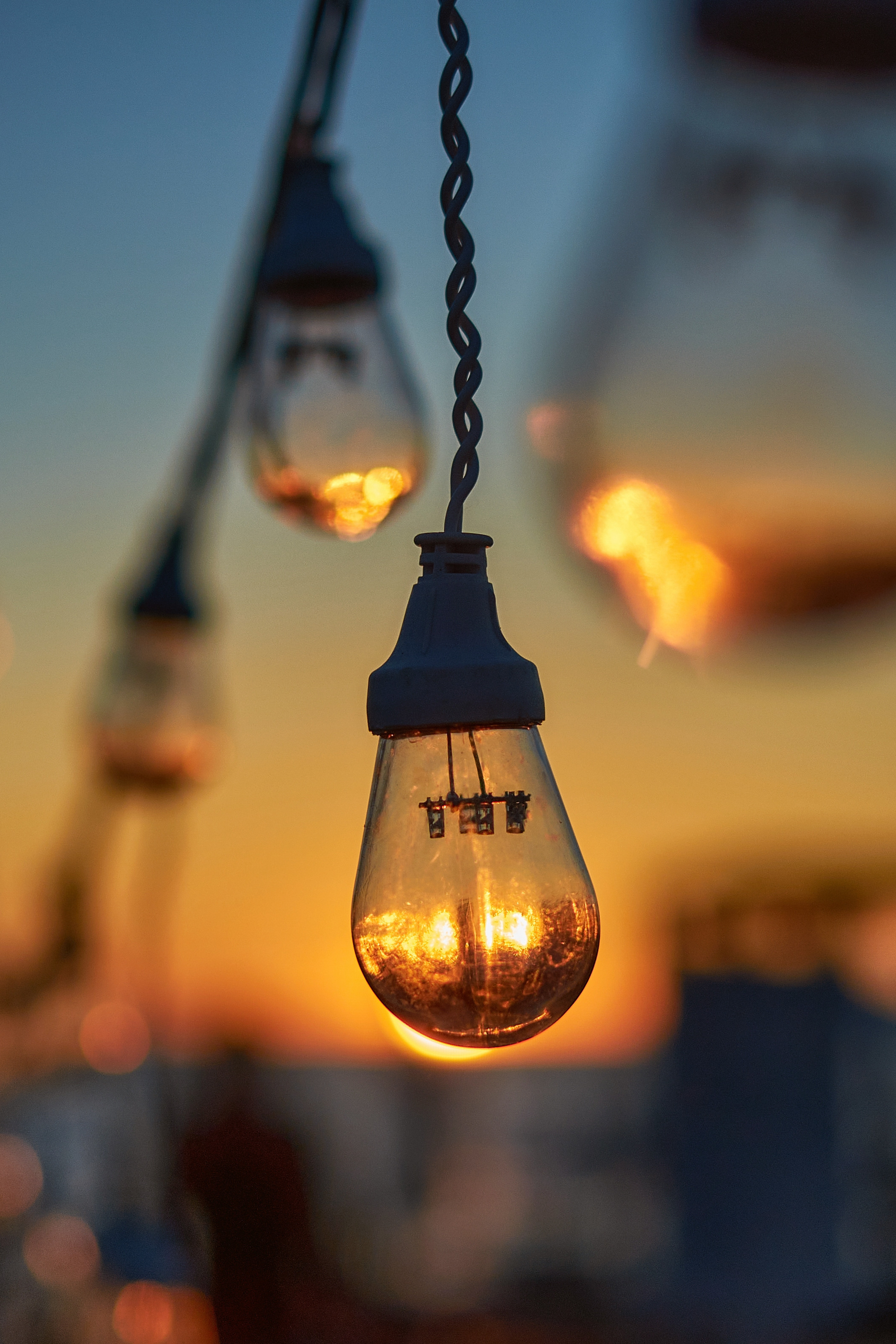 Гирлянда из лампочек на фоне заходящего солнца