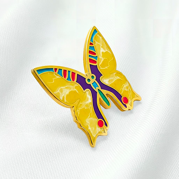 Фотография значка литьём или штамповкой с покрытием позолотой и мраморной эмалью эпола, с инкрустацией камнями