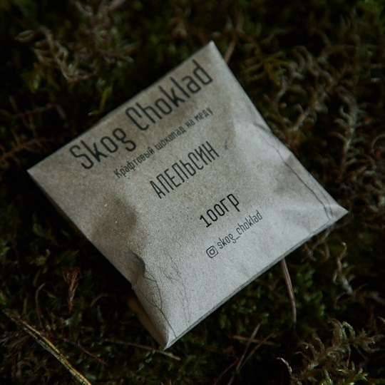 Атмосферное фото упаковки шоколада Skog Choklad на зелёном мху.