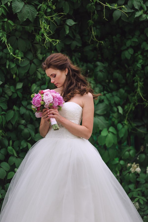 Молодожены, обнимающие друг друга на фоне леса, окруженного цветами весны