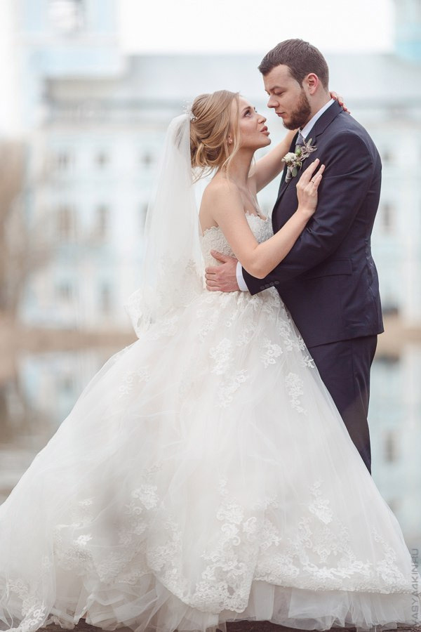 Молодые, целующиеся под огромным фонтаном, полным цветочных брызг, окружающих их