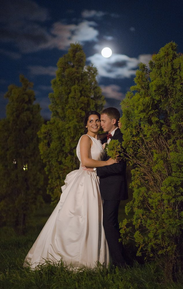 Новобрачные трогают друг друга за руки на танцполе, окруженные молодежью, создавая атмосферу праздника и радости