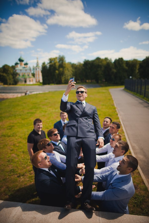 Молодых в окружении гостей, празднующих свадьбу под зонтом с тысячами блесток и огней