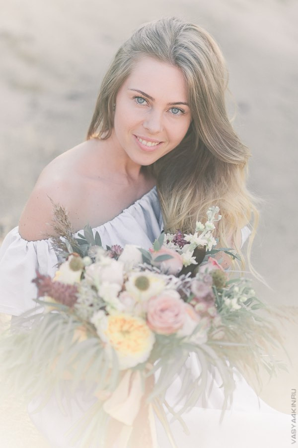 Портретная фотография, на которой невеста воздевает голову, а жених улыбается, выражая радость и счастье