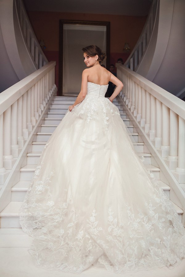 Фотография с гламурной свадьбы в Ярославле, где молодожены идут по дорожке, усыпанной розовыми лепестками