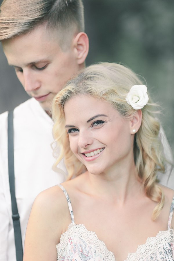 Молодые жених и невеста, стояли вдали один от другого на пивной фабрике, где их отражение отразилось в блестящих баках со свежим пивом