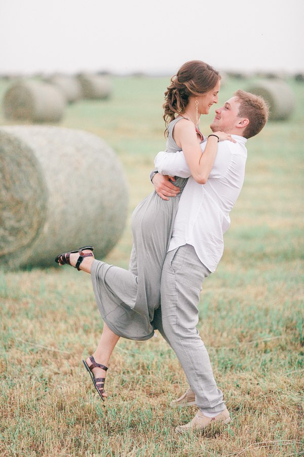 Невеста и ее жених, размазывающие себе торт по лицам, весело и смешно смотря на друг друга