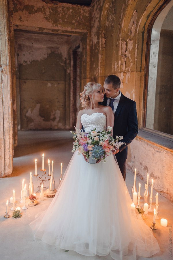 Невеста и жених идут по дорожке с витражными стеклами и величественными фонтанами, на фоне дворца, на их роскошной свадьбе в Ярославле