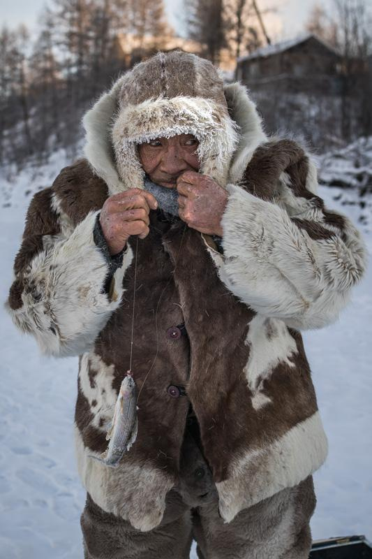 A retired reindeer breeder Konstantin Androsov caught a grayling during ice fishing. 