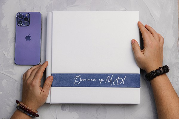 Фотокнига на рабочем столе рядом с iPhone для понимания масштаба: лаконичный современный дизайн и премиальное исполнение.