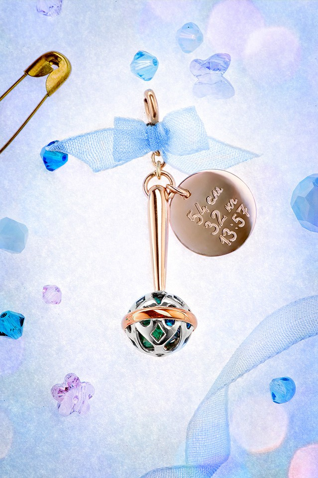 Ювелирная подвеска на булавке на лёгком фоне.