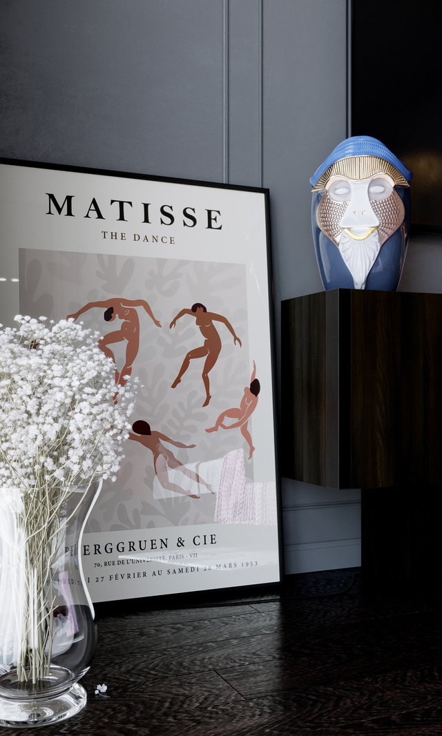 Деталь интерьера с книгой о Матиссе, стеклянной вазой и декоративной маской.