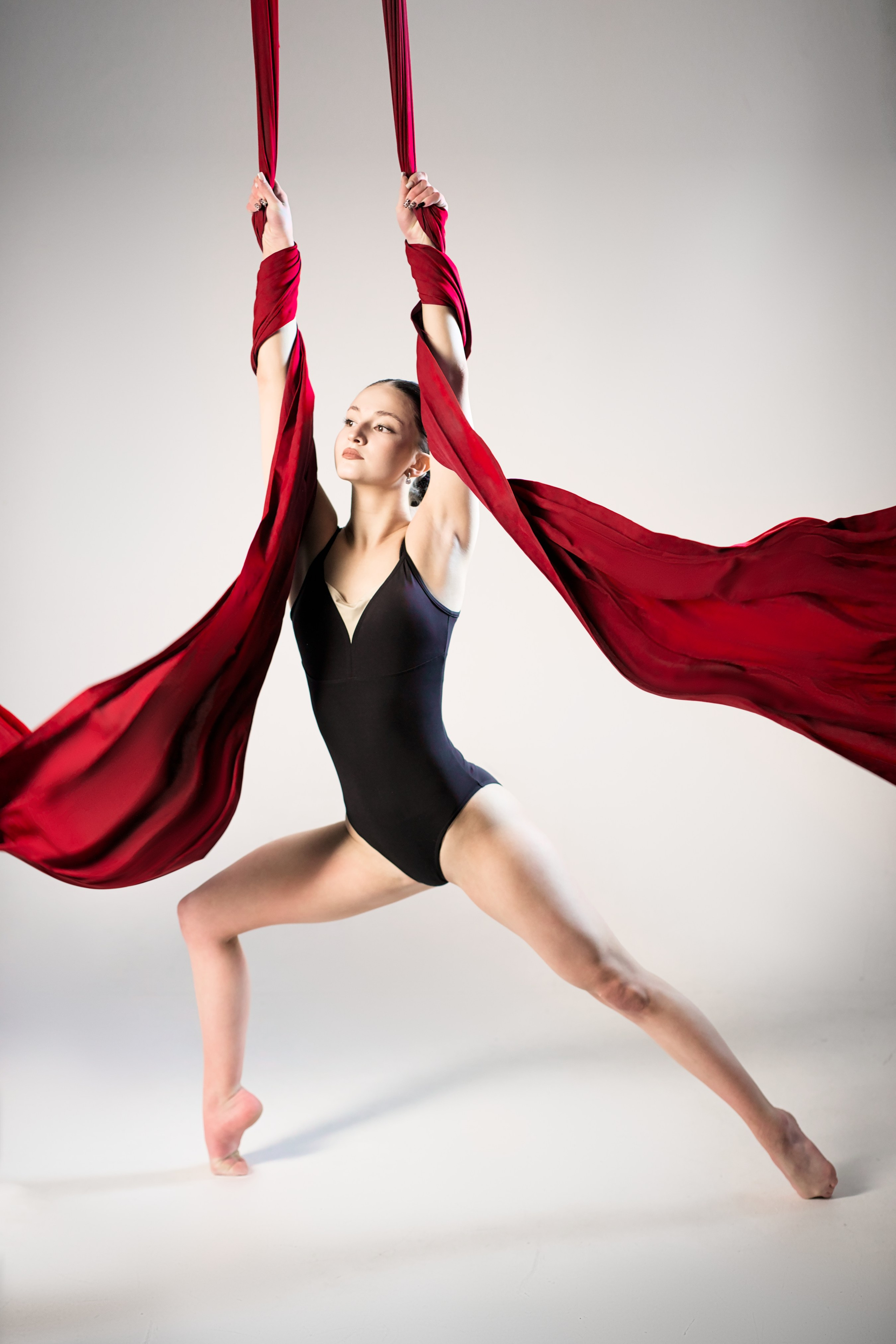 Художественная гимнастка в гибкой позе с мячом, зеркальное отражение и цветной свет в стиле спортарт