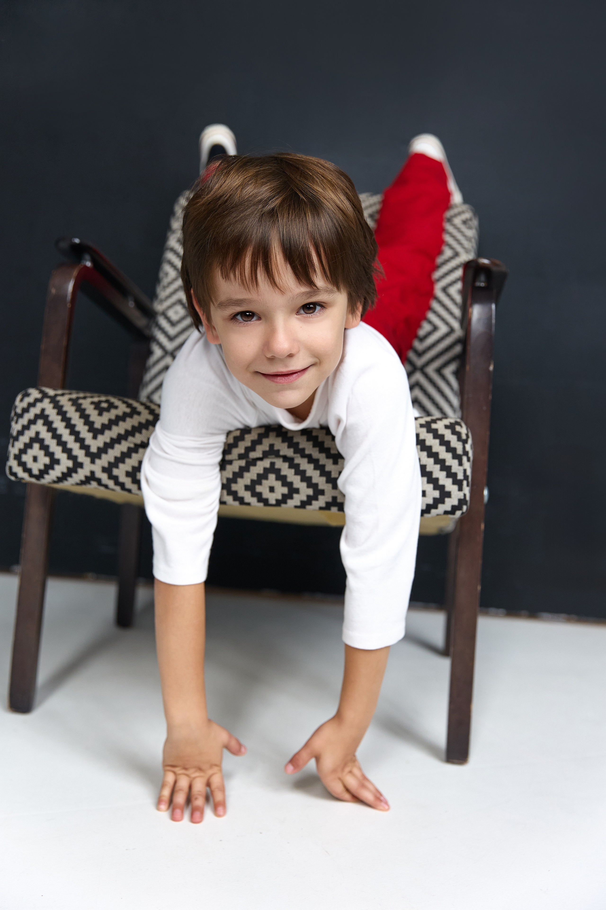 Детская фотосессия мальчика 4-6 лет — веселая поза на стуле в студии, репортажная детская фотография Минск