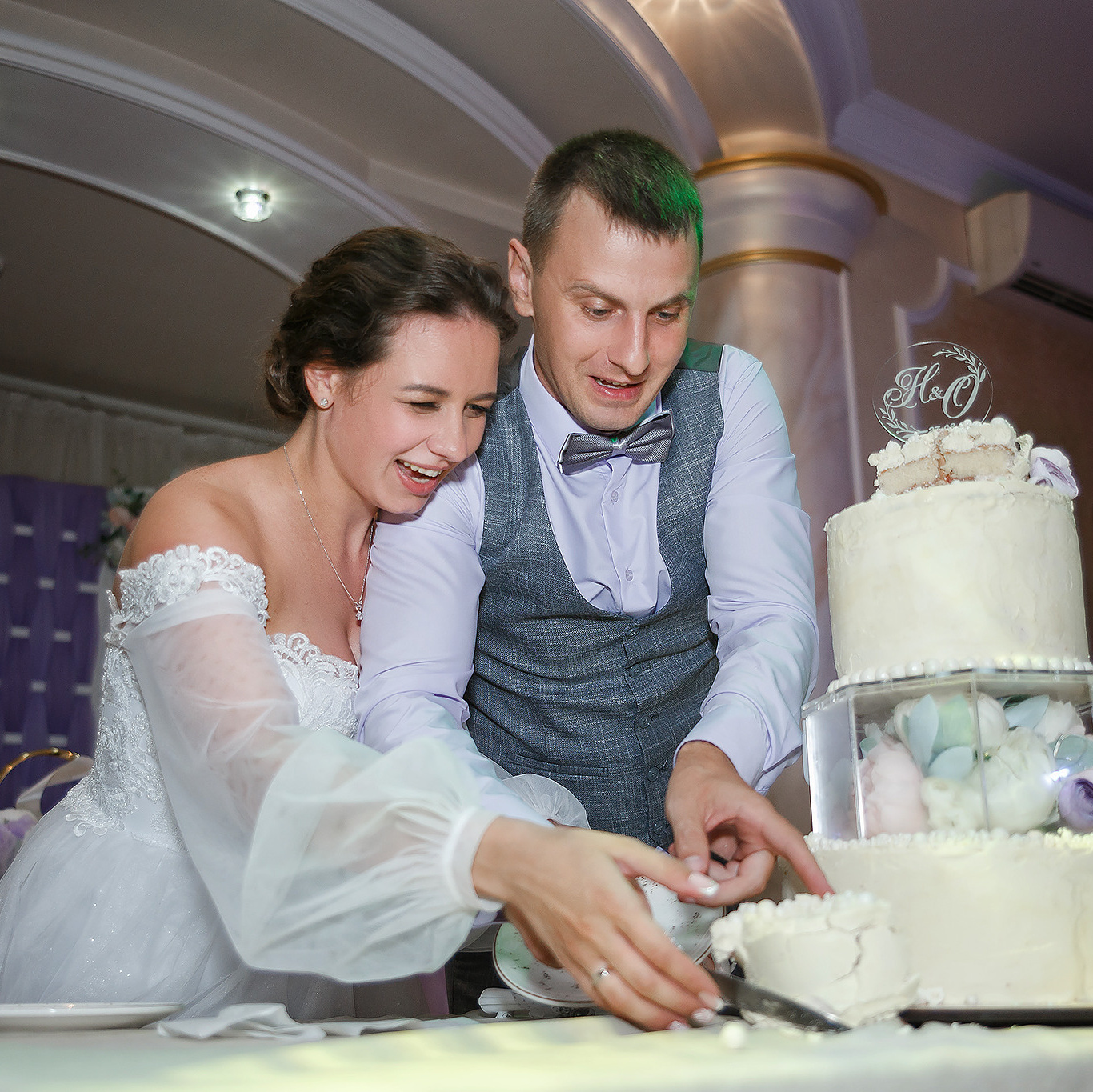 жених и невеста режут свадебный торт