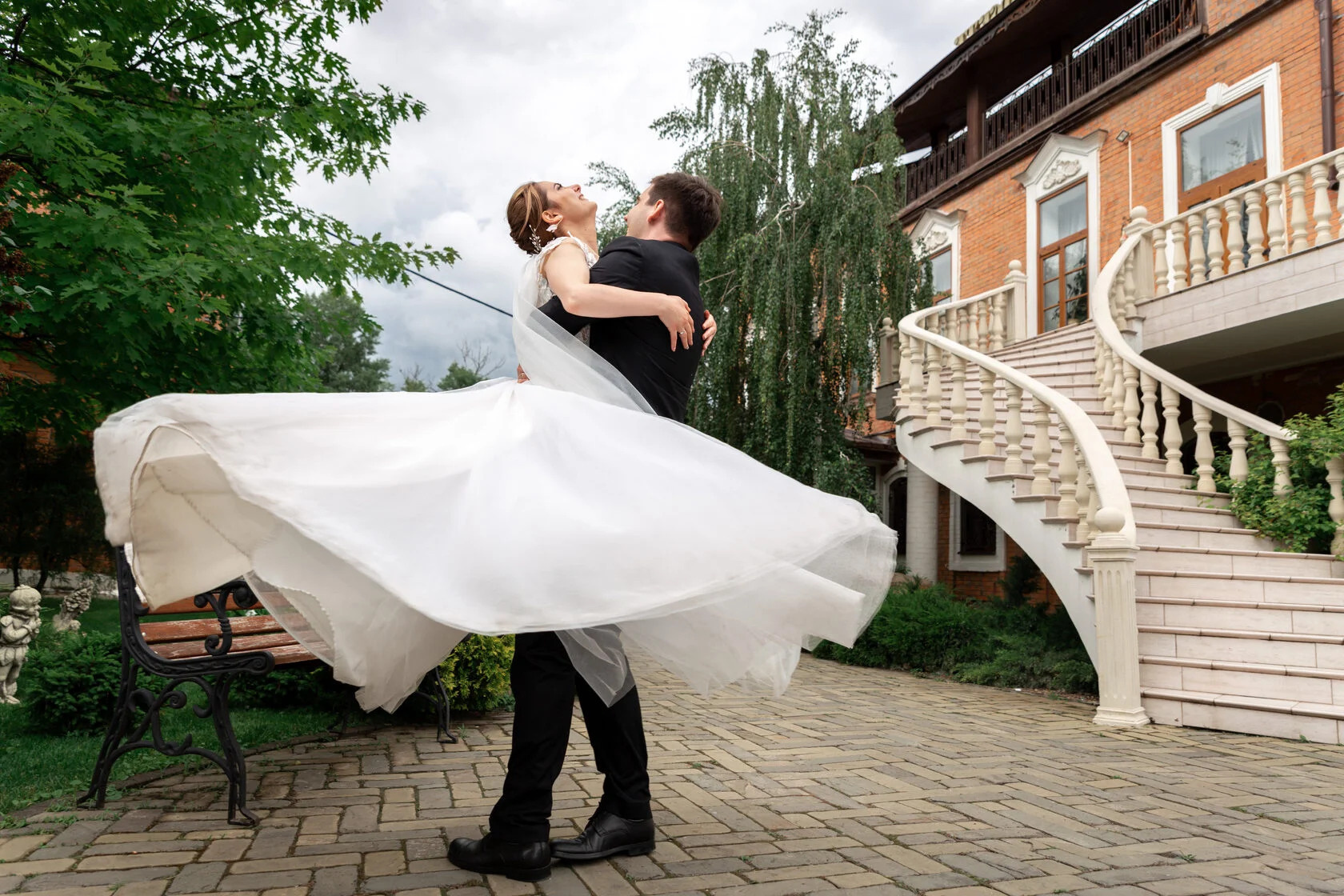 Жених кружит невесту в развевающемся платье