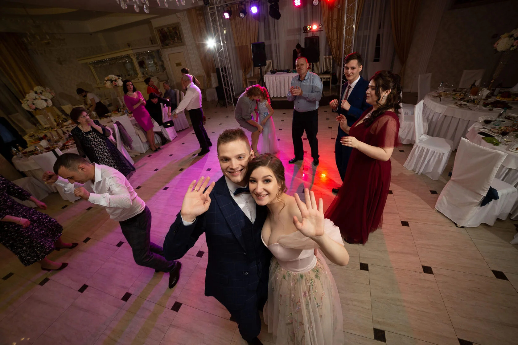 Молодожены на свадебном банкете танцуют с гостями