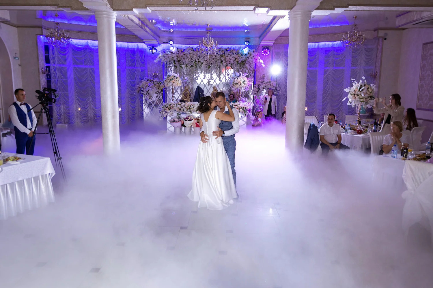 Жених и невеста танцуют в бальном зале, наполненном облаками