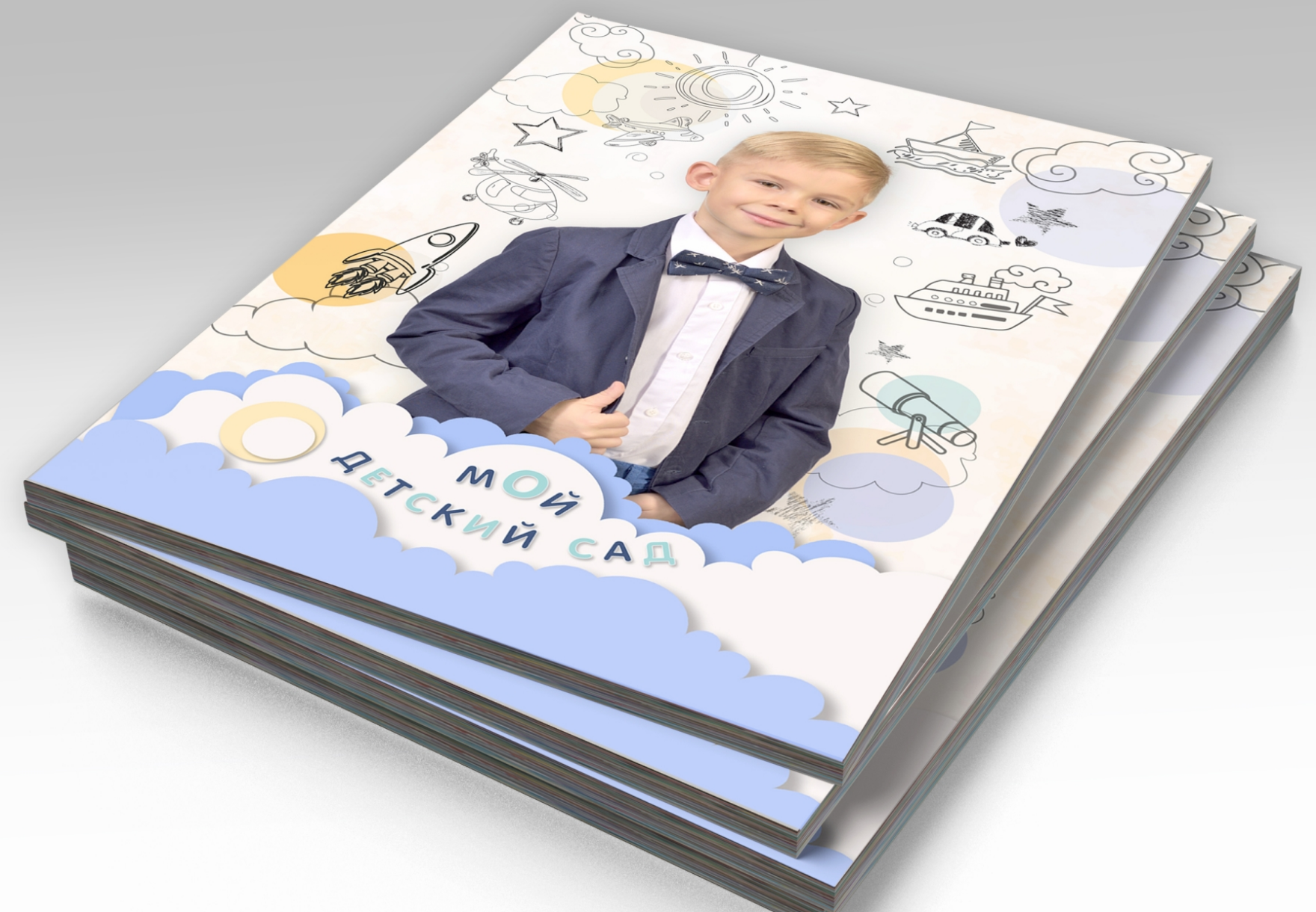Стопка выпускных альбомов детского сада, на титульной стороне портрет выпускника.
