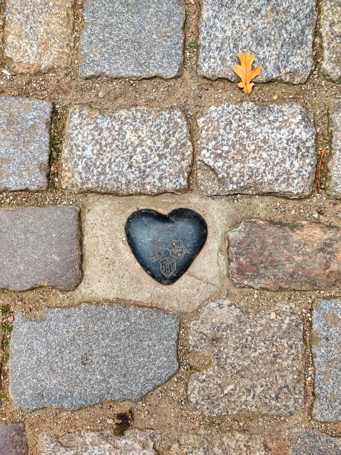 Камень в форме сердца с гербом Кёнигсберга, встроенный в брусчатку возле могилы Канта