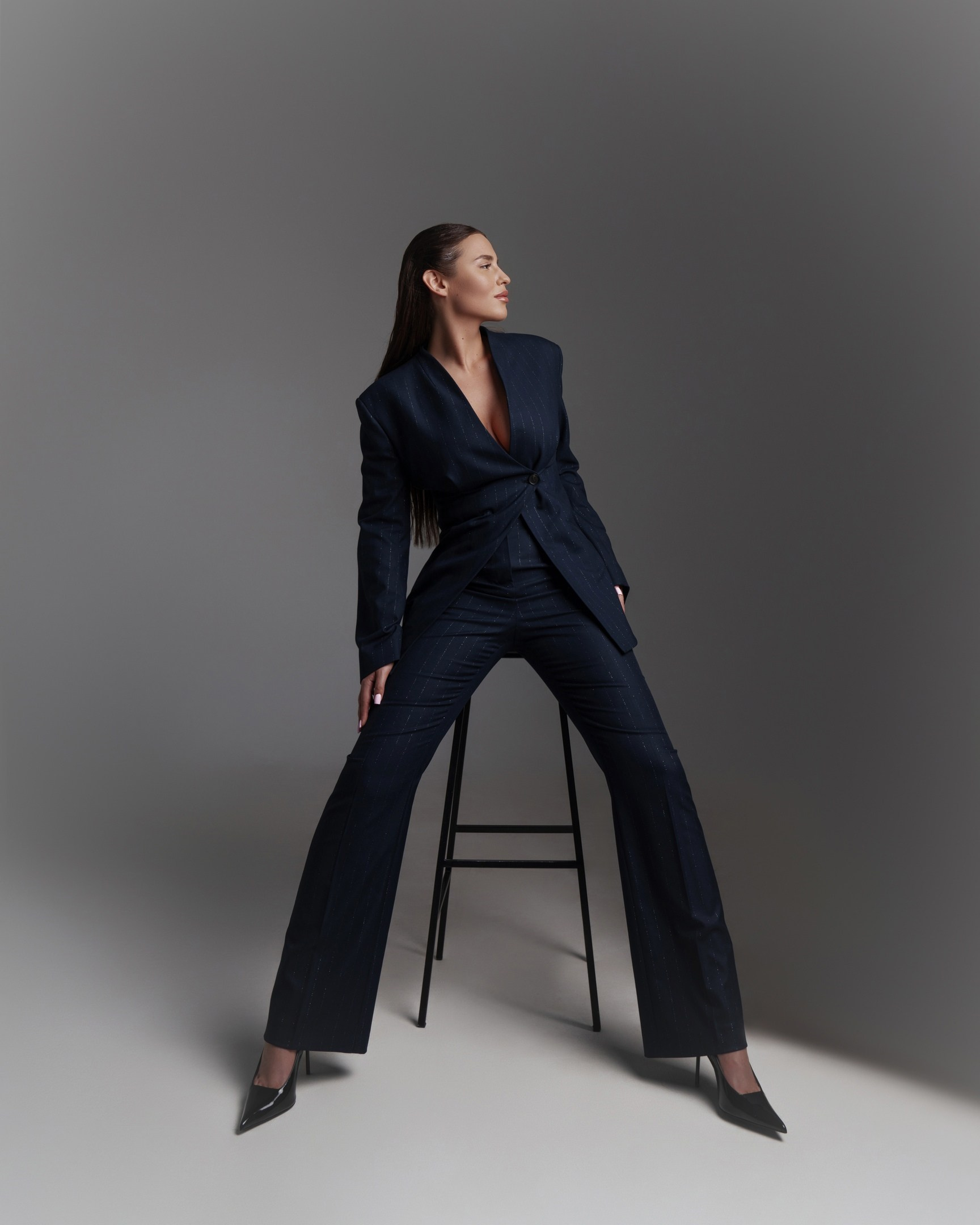 На этой фотографии запечатлена девушка в фотостудии. Снимок выполнен в тёмных тонах, что придаёт ему загадочность и драматизм.