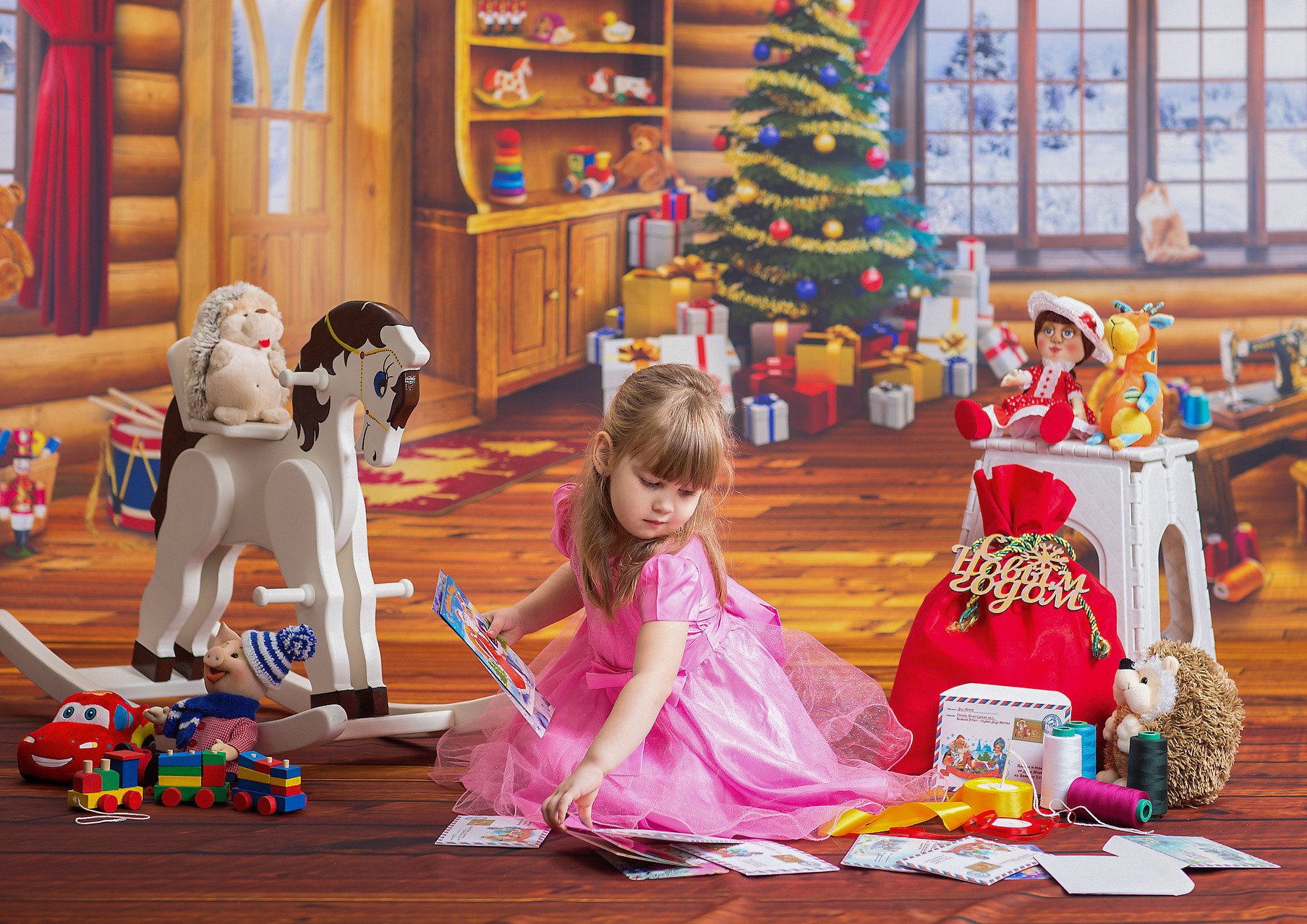 Новогодняя костюмированная выездная фотосессия Мастерская игрушек. Девочка разбирает письма от деда Мороза.