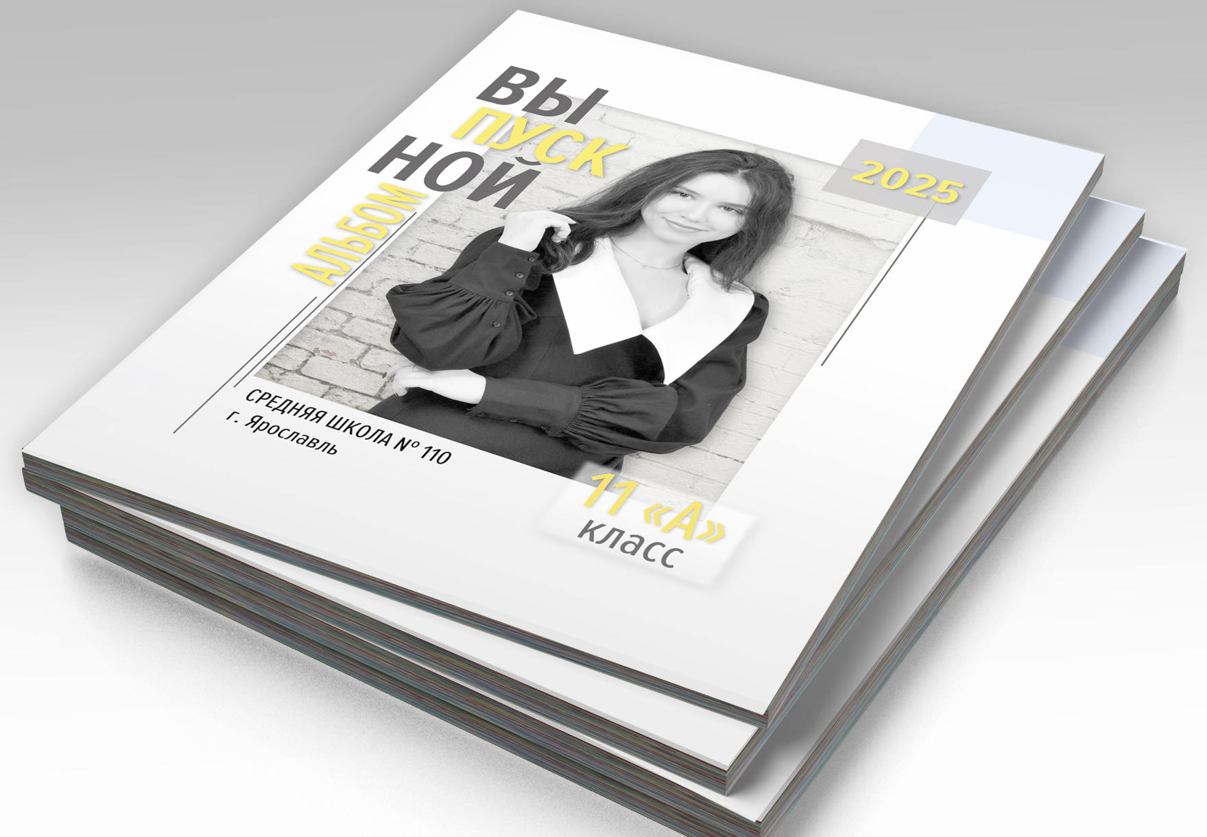 Стопка альбомов выпускника средней школы, на титульной стороне портрет выпускницы.