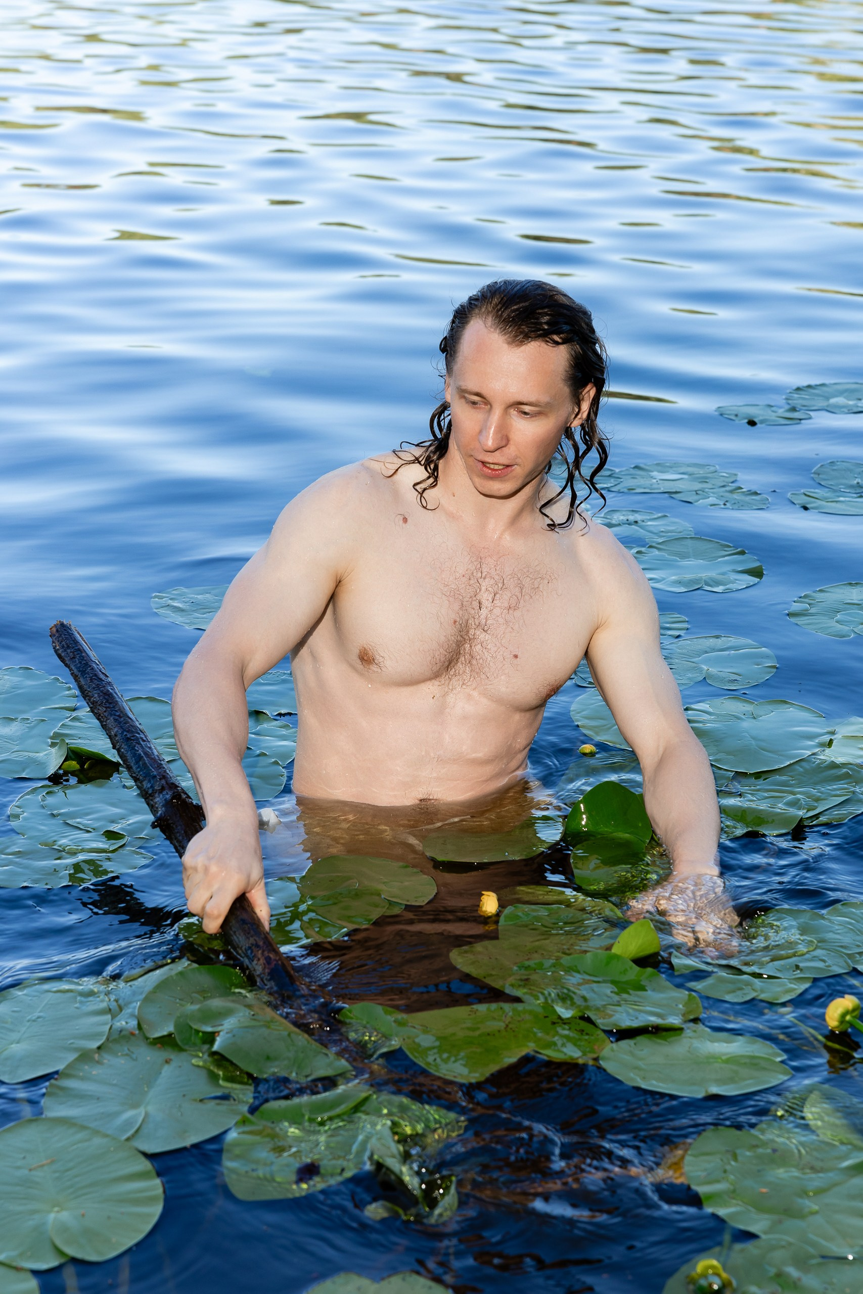 Мужчина с накаченным телом в озере среди кувшинок