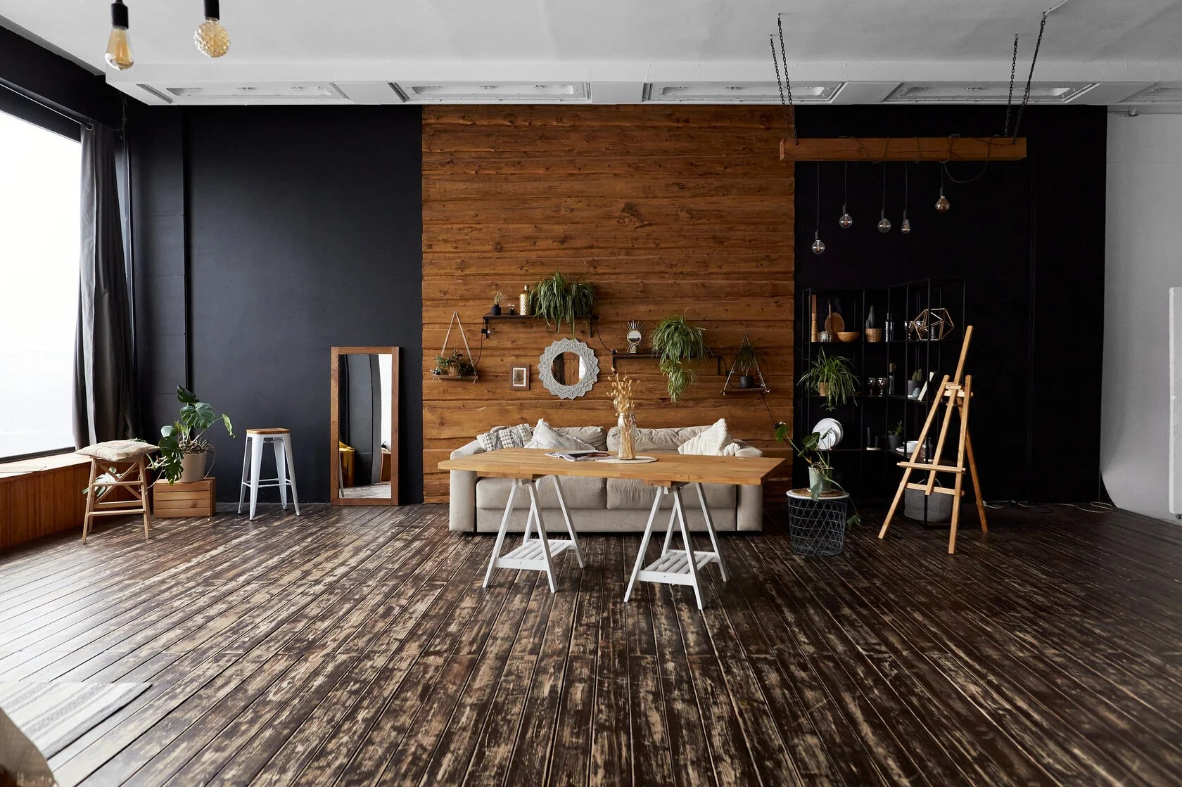 панорамный снимок зала фотостудии в тёплых тонах со столом и диваном, искусственными растениями