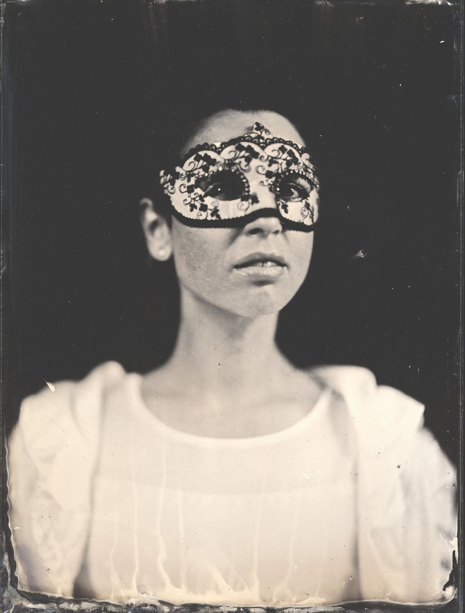 Черная-белый амбротип на темном фоне девушки в маске. 