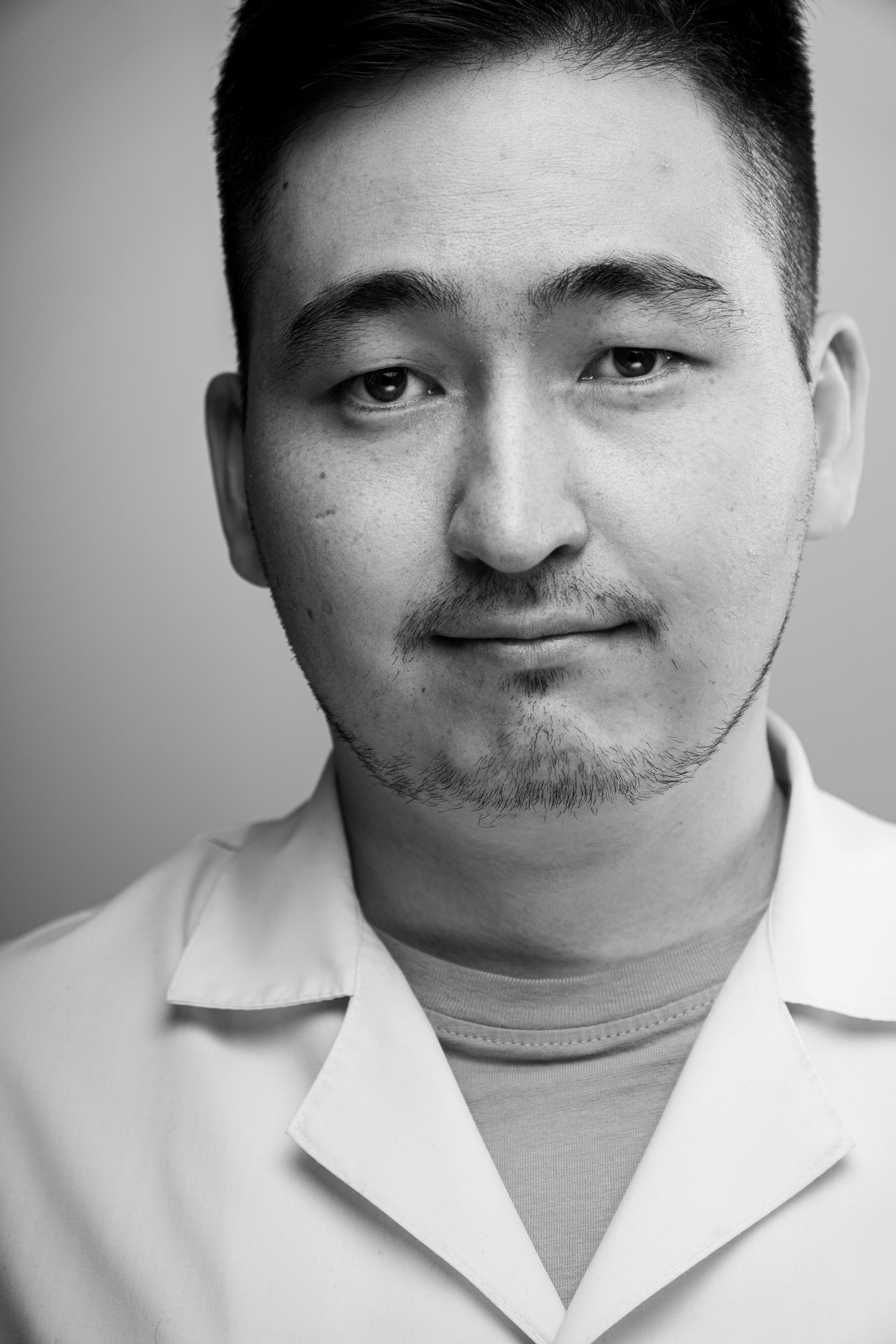 Чёрно-белый портрет мужчины в медицинской одежде — деловая и лаконичная студийная портретная фотография в Астане