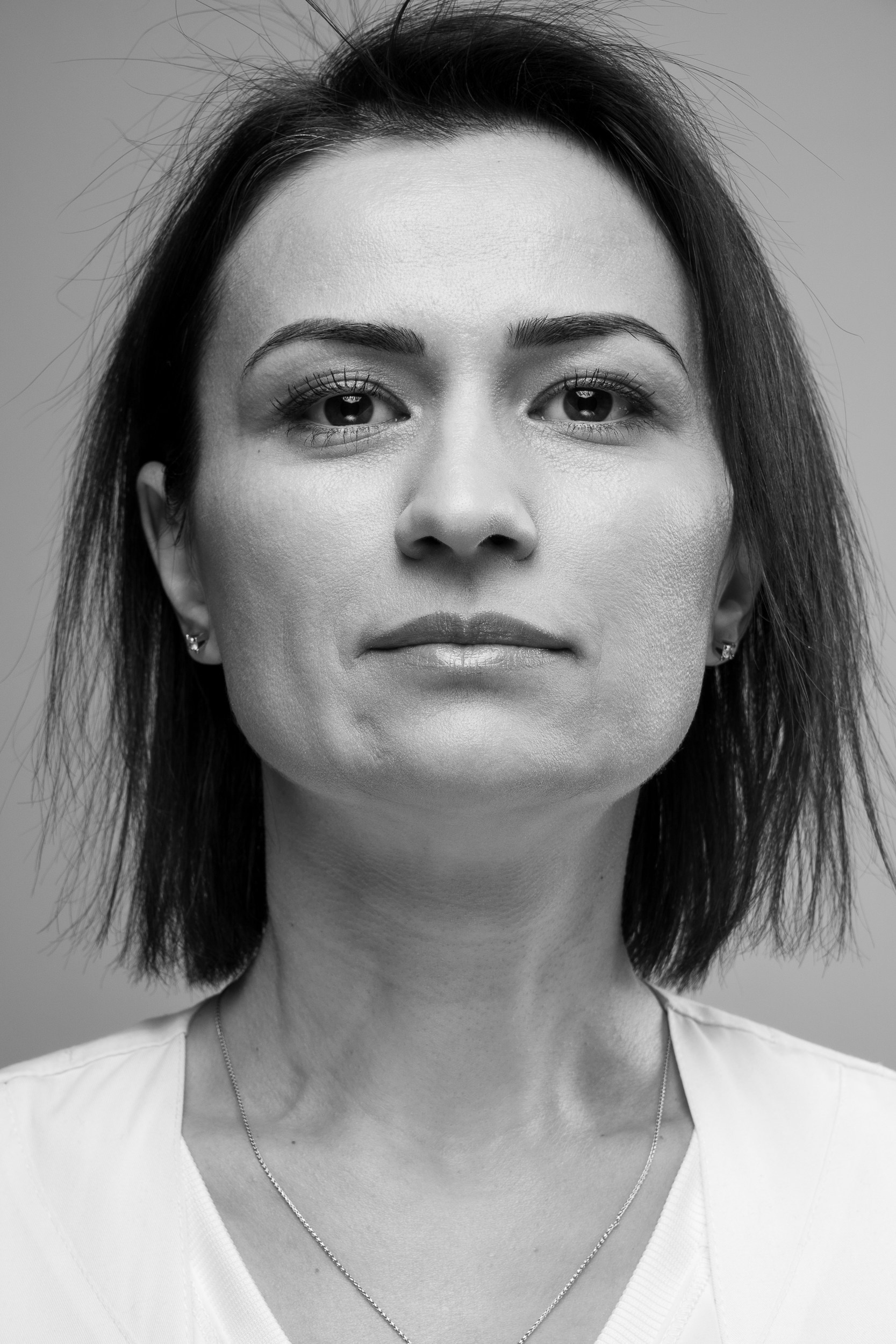 Чёрно-белый портрет женщины на однотонном фоне — минималистичная художественная портретная фотография.