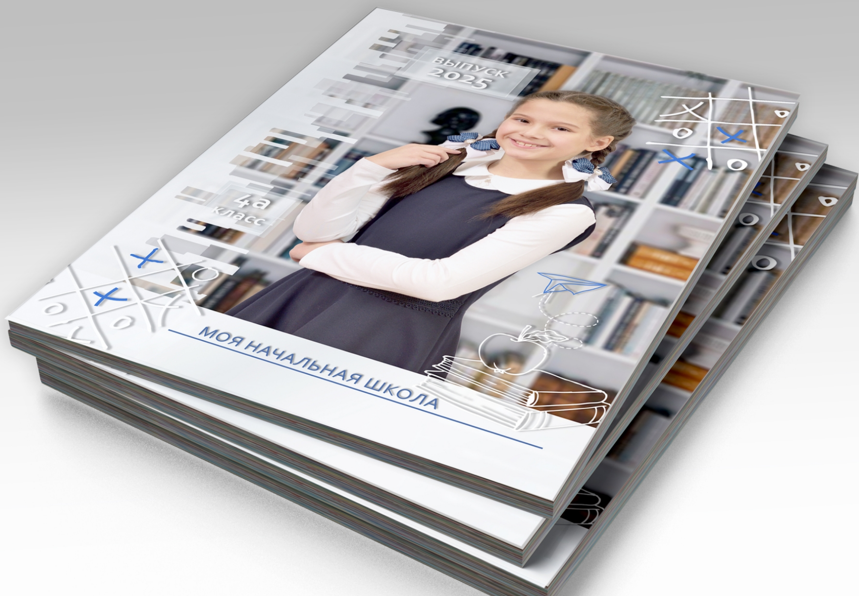 Стопка альбомов выпускника начальной школы, на титульной стороне портрет выпускницы.