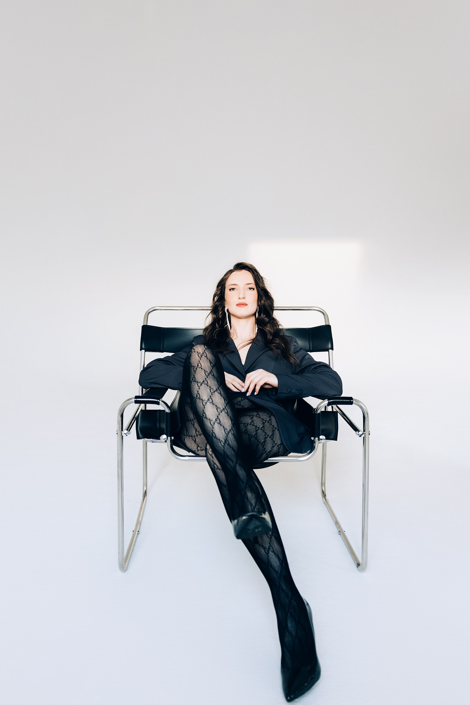 Девушка в ажурных колготках на стуле