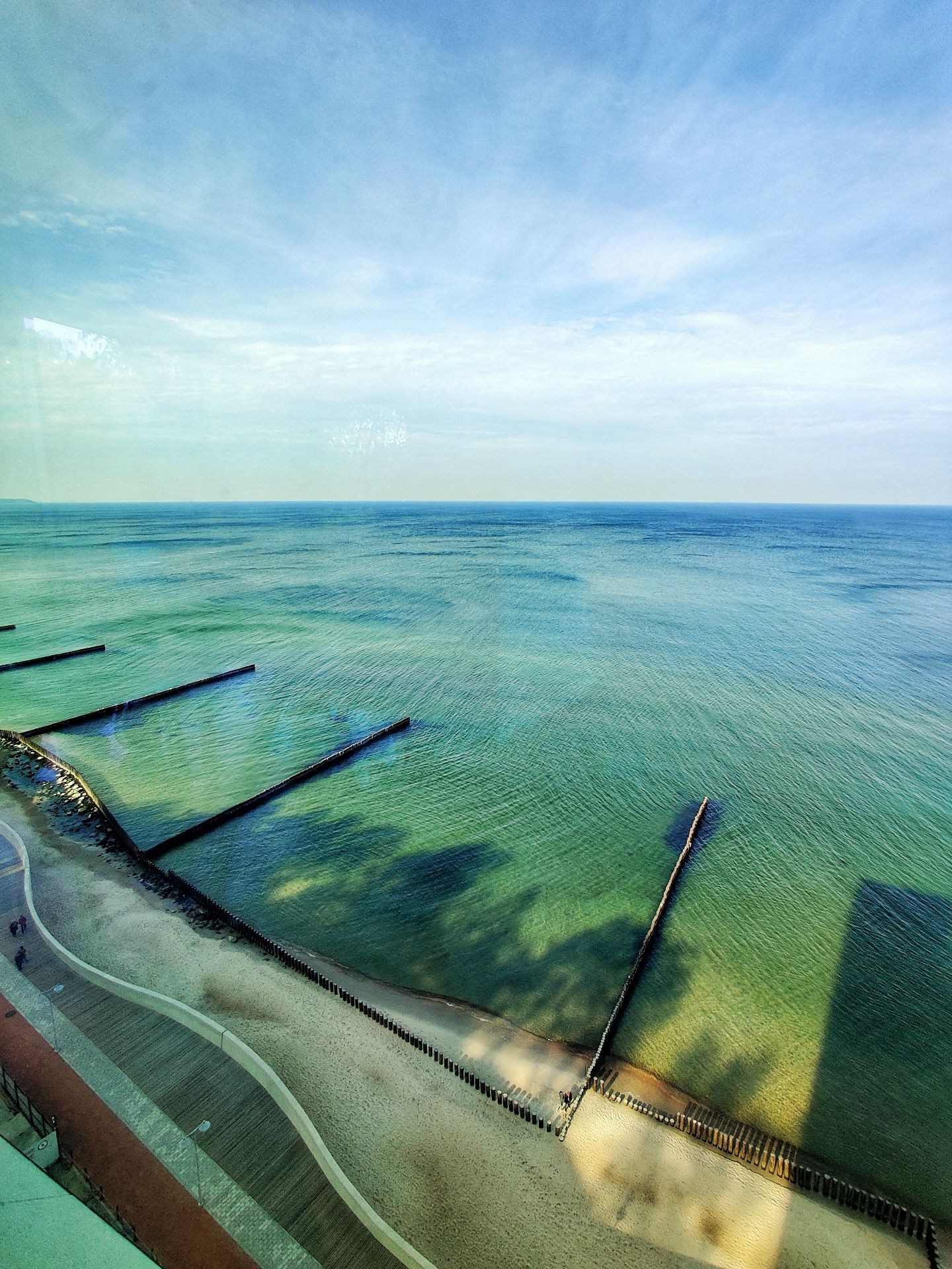 Вид на Балтийское море с пирсами и песчаным пляжем с высоты