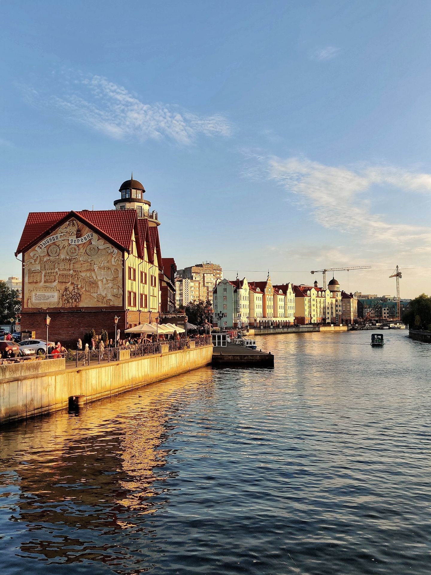 Набережная Рыбной деревни в Калининграде с видом на реку и дома с красными крышами