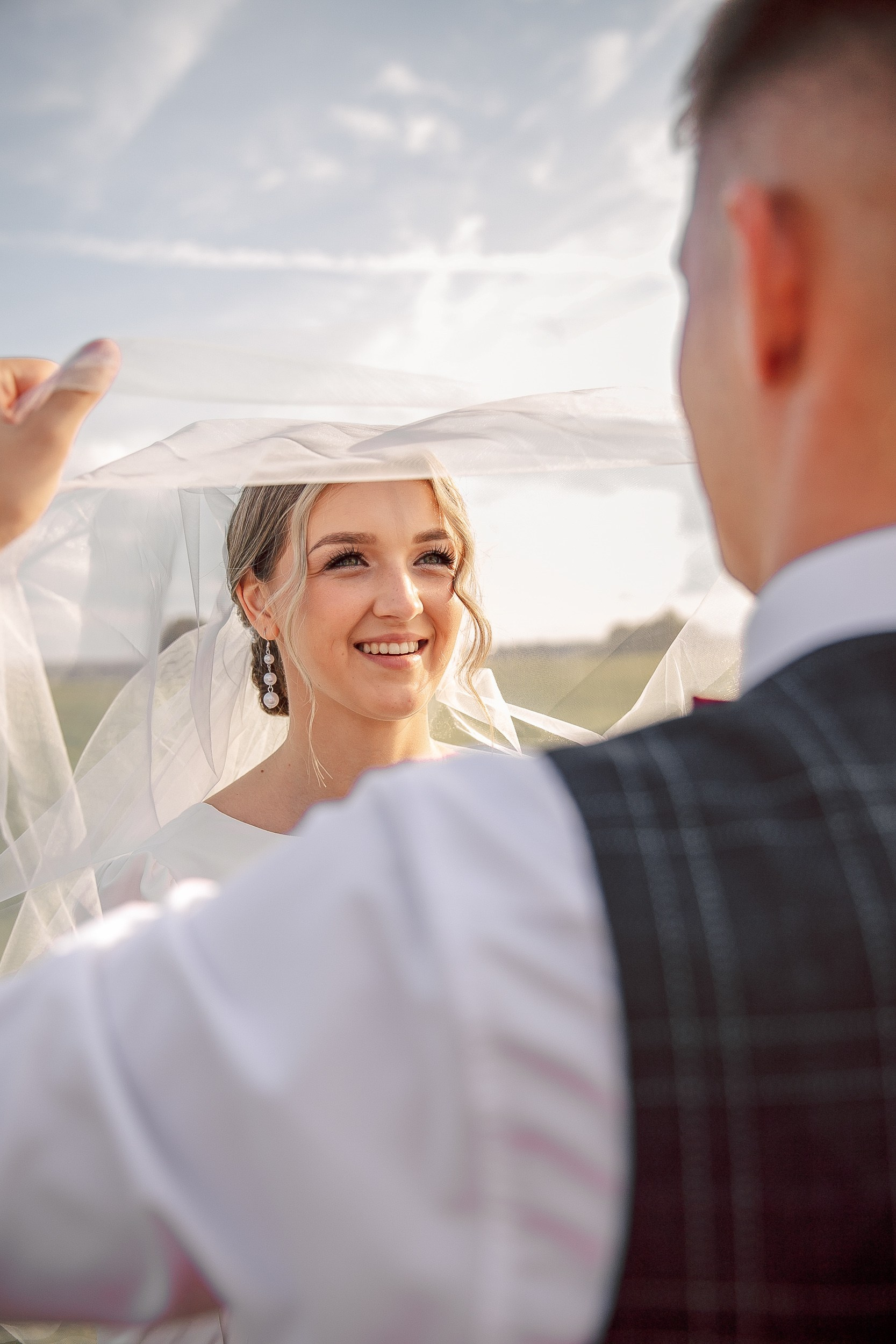 Жених поднимает фату невесты