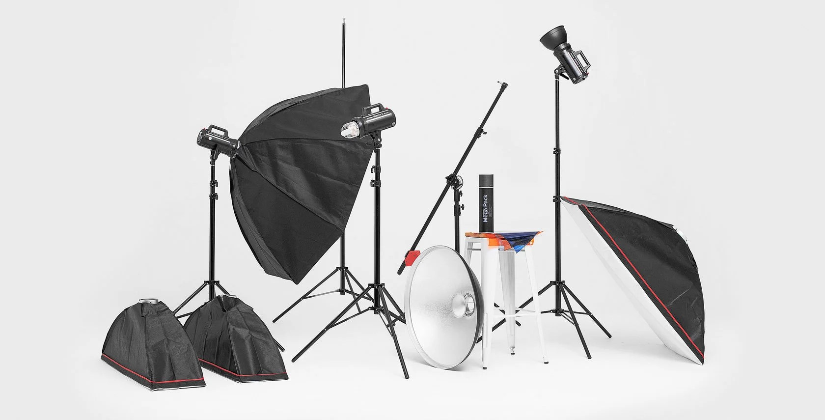 набор фотооборудования в фотостудии на белом фоне циклорамы со штативами и световыми насадками в виде софтбоксов