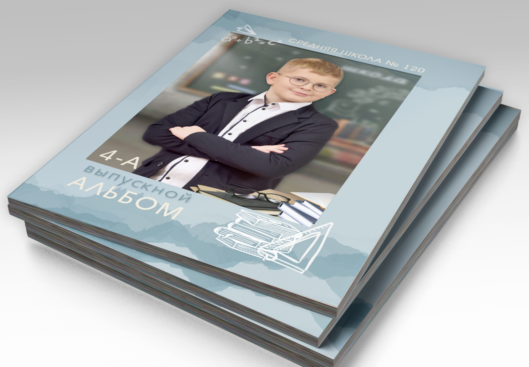 Стопка альбомов выпускника начальной школы, на титульной стороне портрет выпускника.