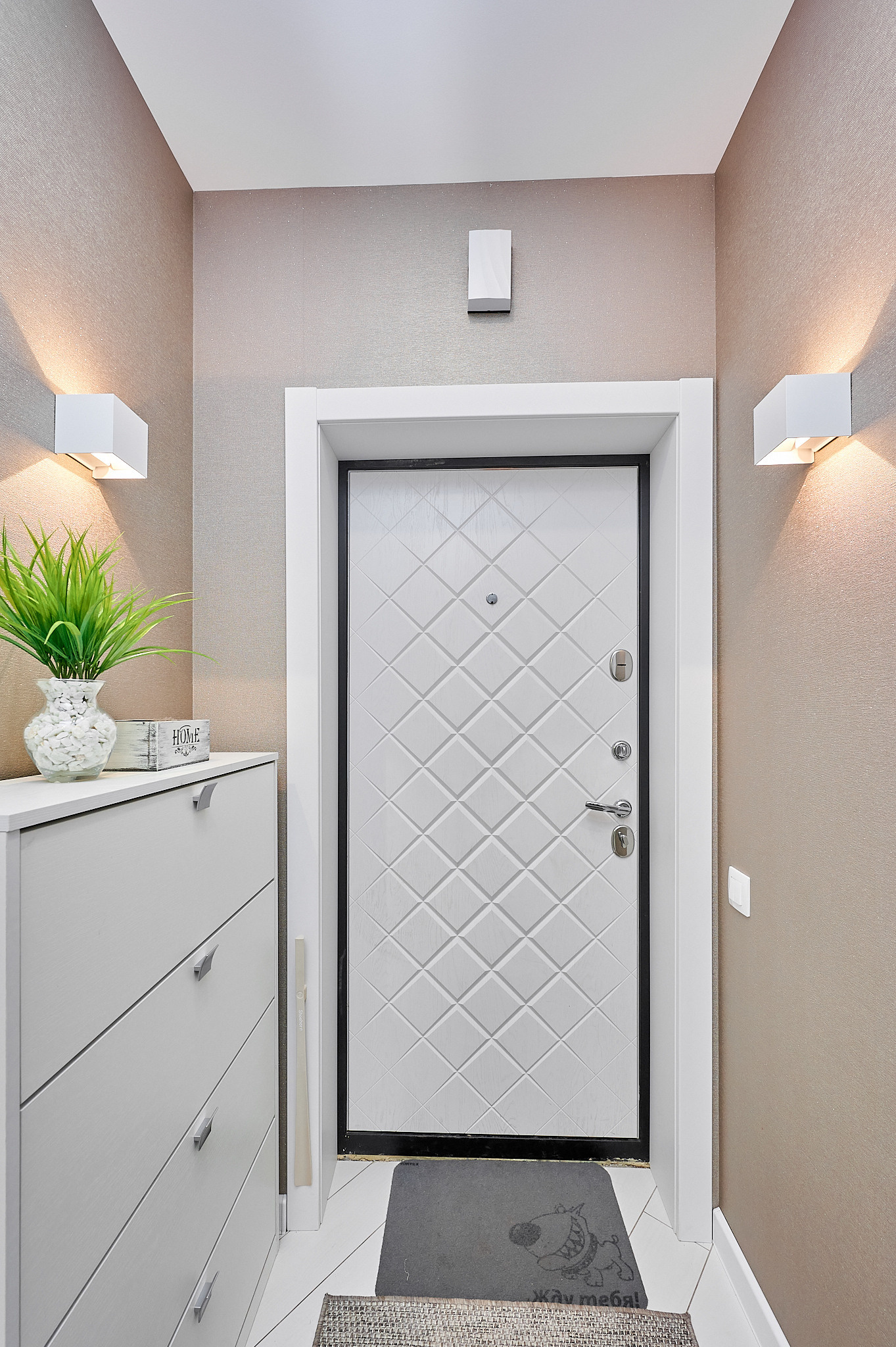 светлая прихожая с включенным светом и белым комодом