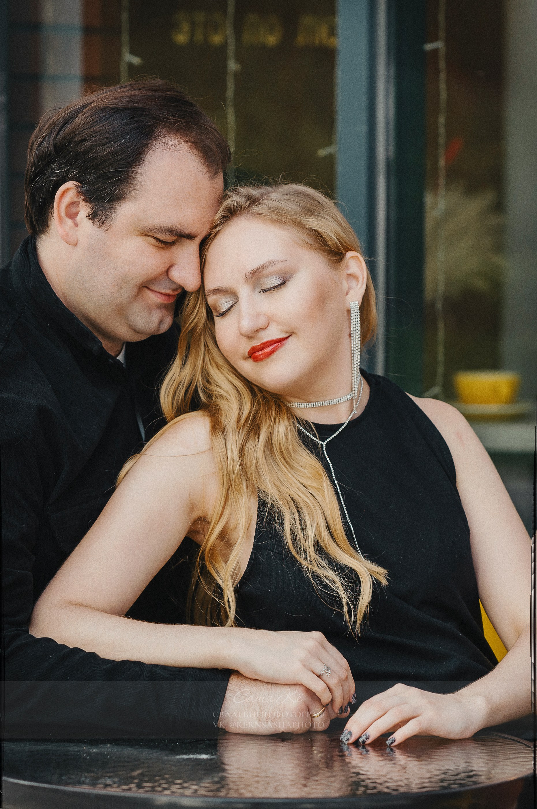 Пара позирует на фоне городских огней вечером