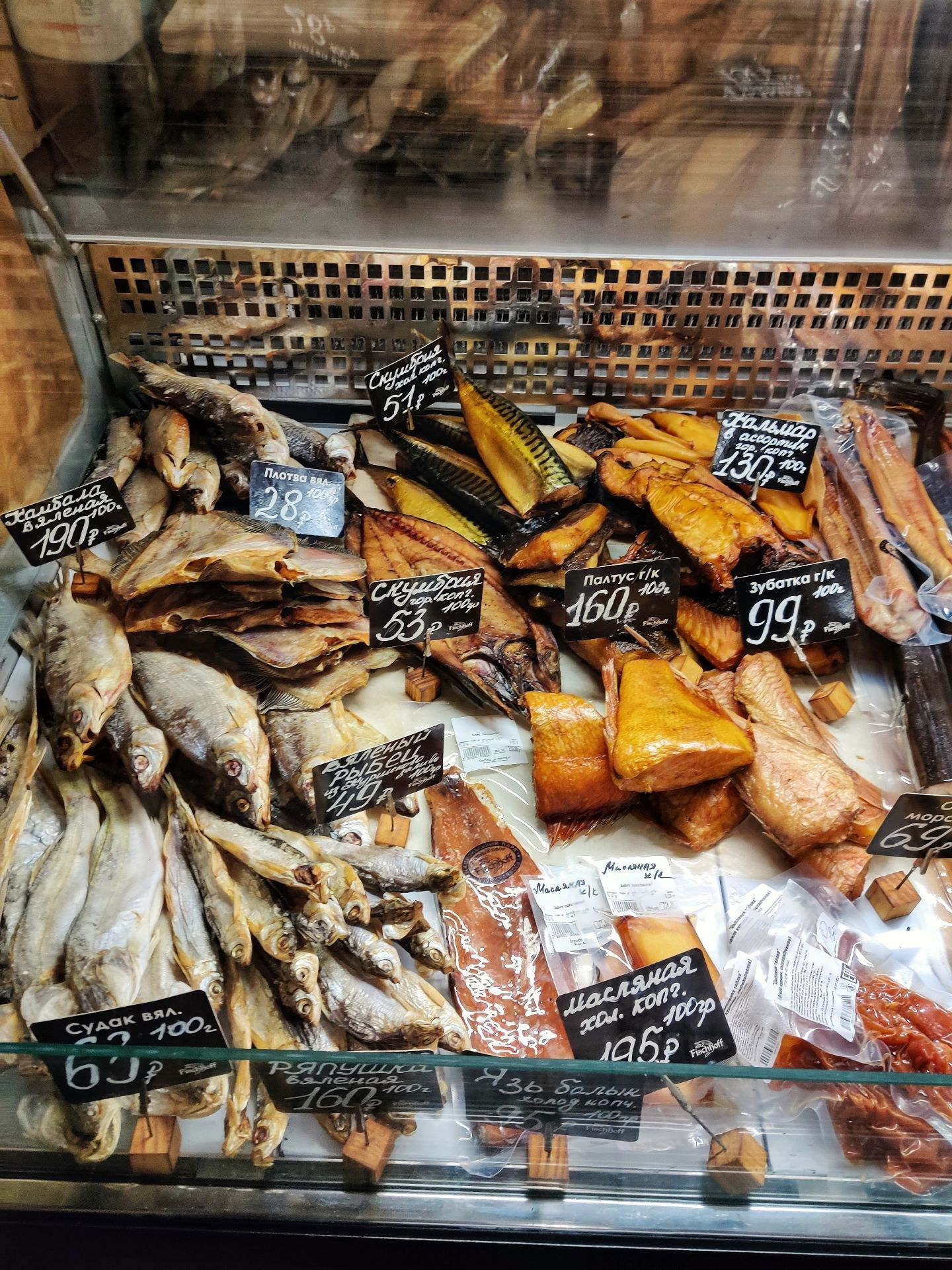 Витрина магазина с ассортиментом копчёной и вяленой рыбы с ценниками