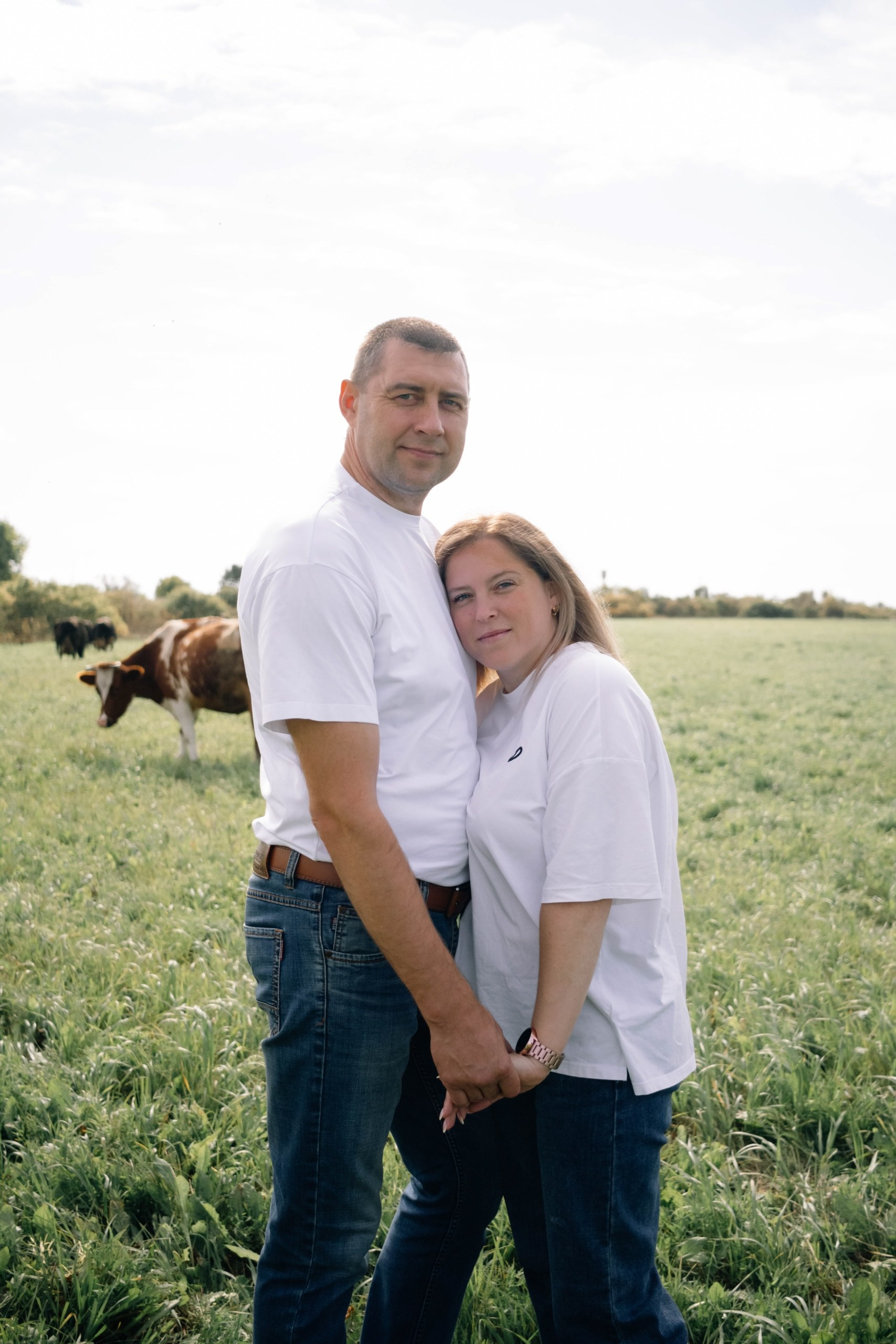 Фотография в поле семейной пары : муж и жена на фоне кров. 