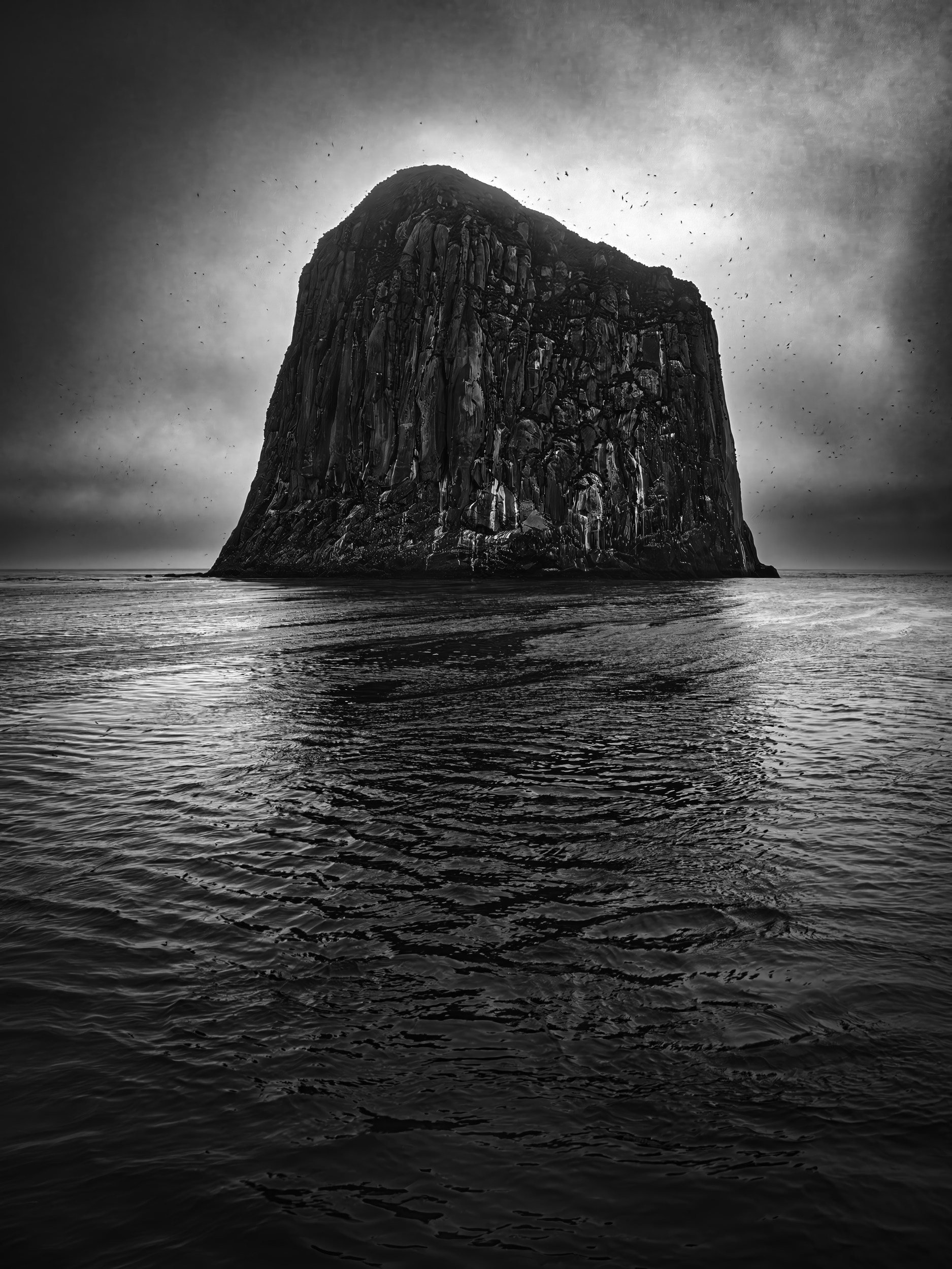 черно-белая фотография скалы "Колпак" на Северных Курилах рядом с островом Янкича