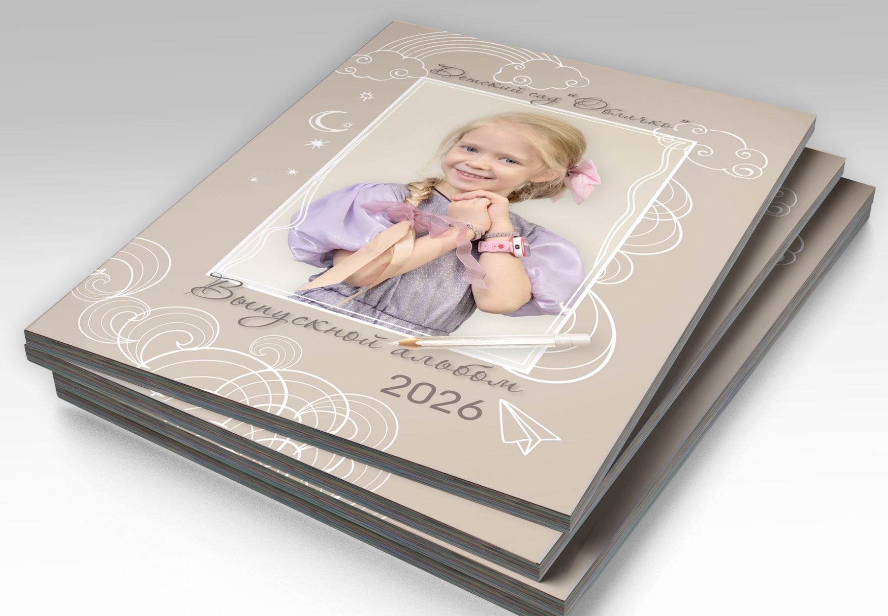 Стопка альбомов выпускника детского сада, на титульной стороне портрет выпускницы.